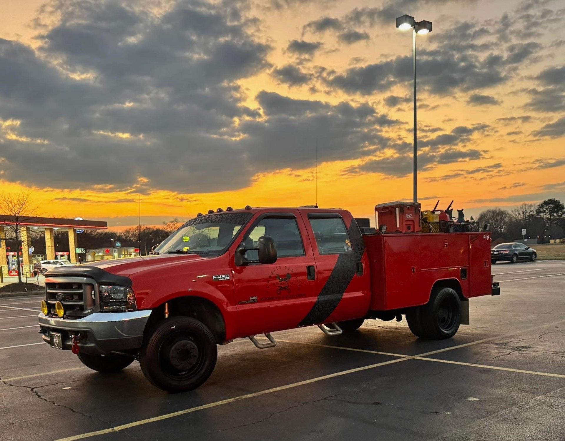 Mobile diesel technician working on a commercial truck at dusk